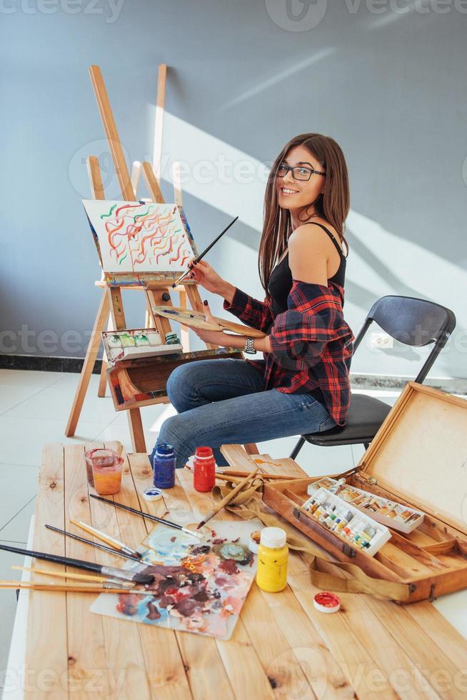 Pretty Pretty Girl artist paints on canvas painting on the easel. photo