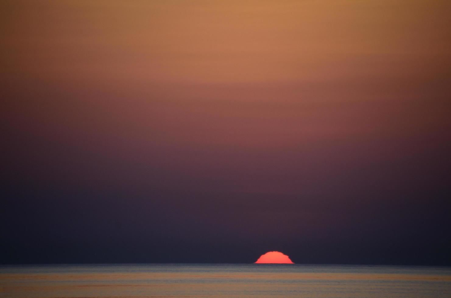 sun on the horizon at sea photo