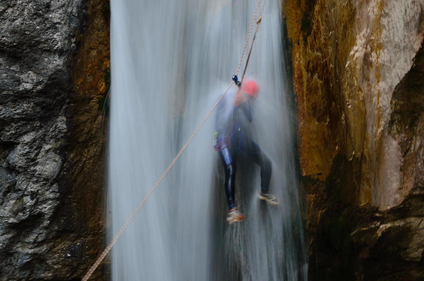 man under waterfall photo