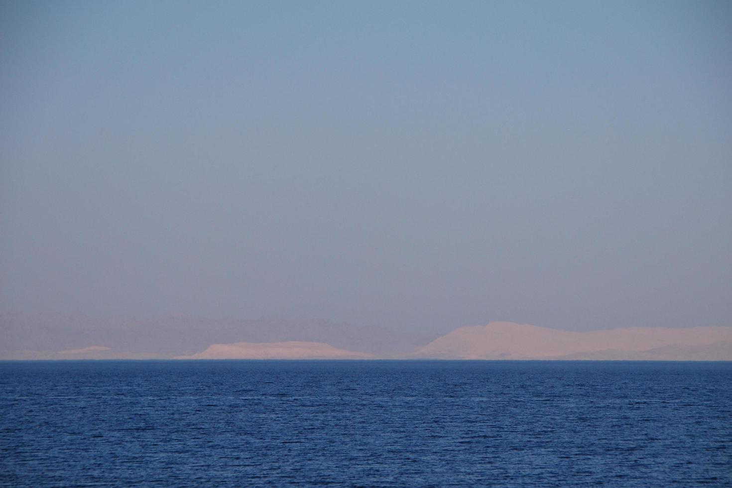 sea and mountain on the horizon photo