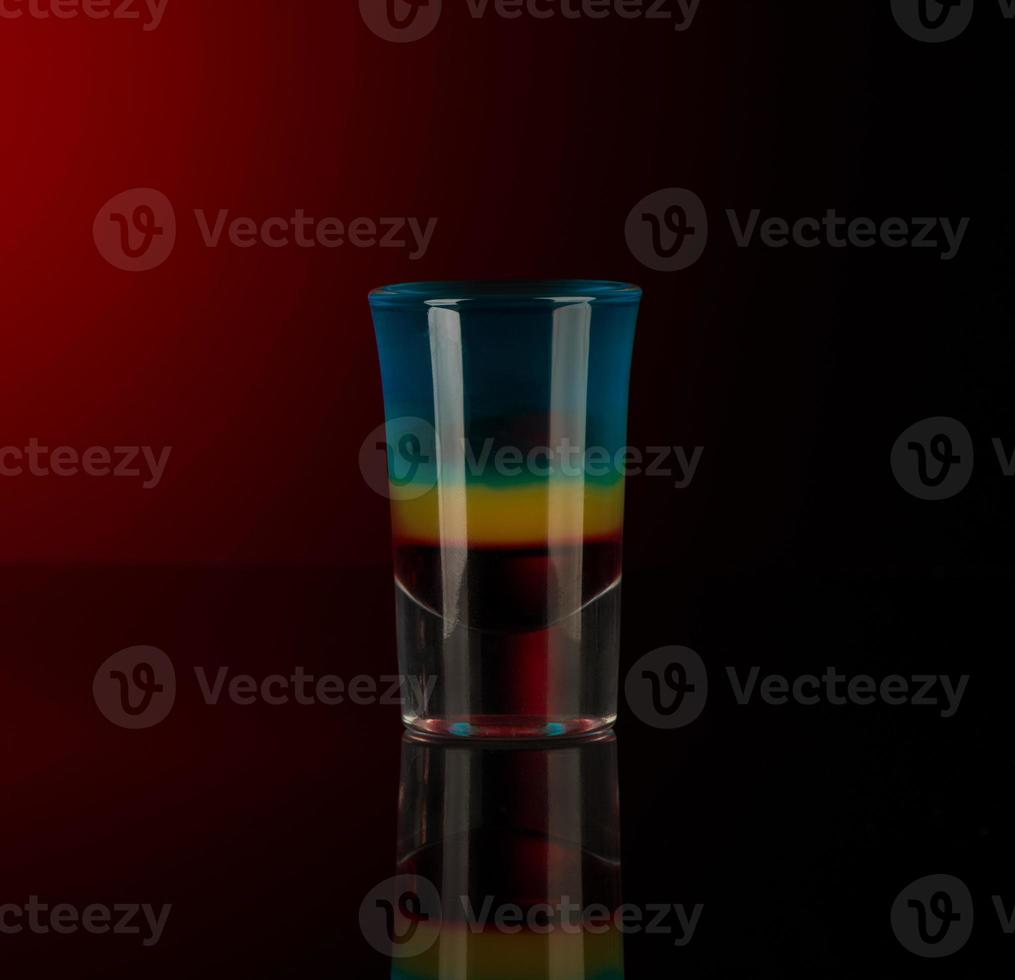 shot glass with alcohol on a dark background photo