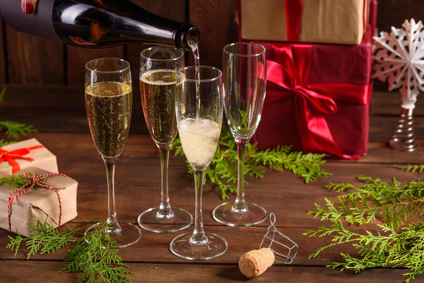 mesa navideña con copas y una botella de vino de champán foto
