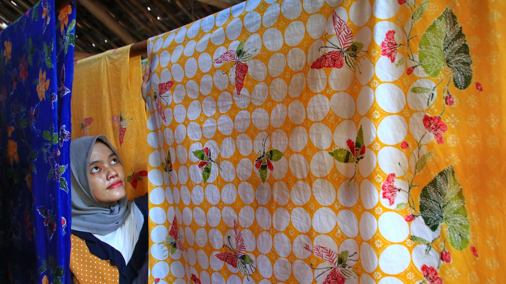 una mujer que está secando tela batik de colores, directamente al sol, pekalongan, indonesia, 7 de marzo de 2020 foto
