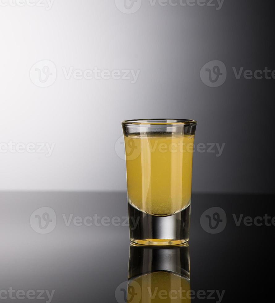 shot glass with alcohol on a dark background photo