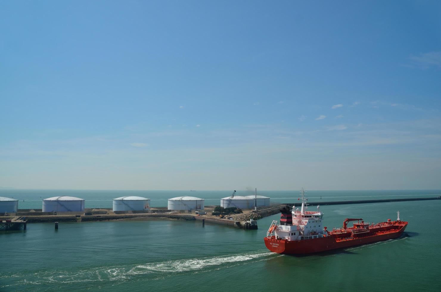 red cargo ship in a harbor photo