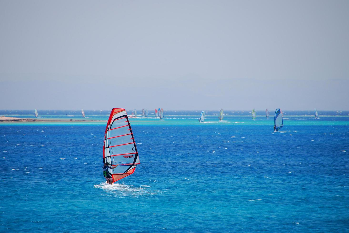 windsurfer in the sea with many others in the background photo