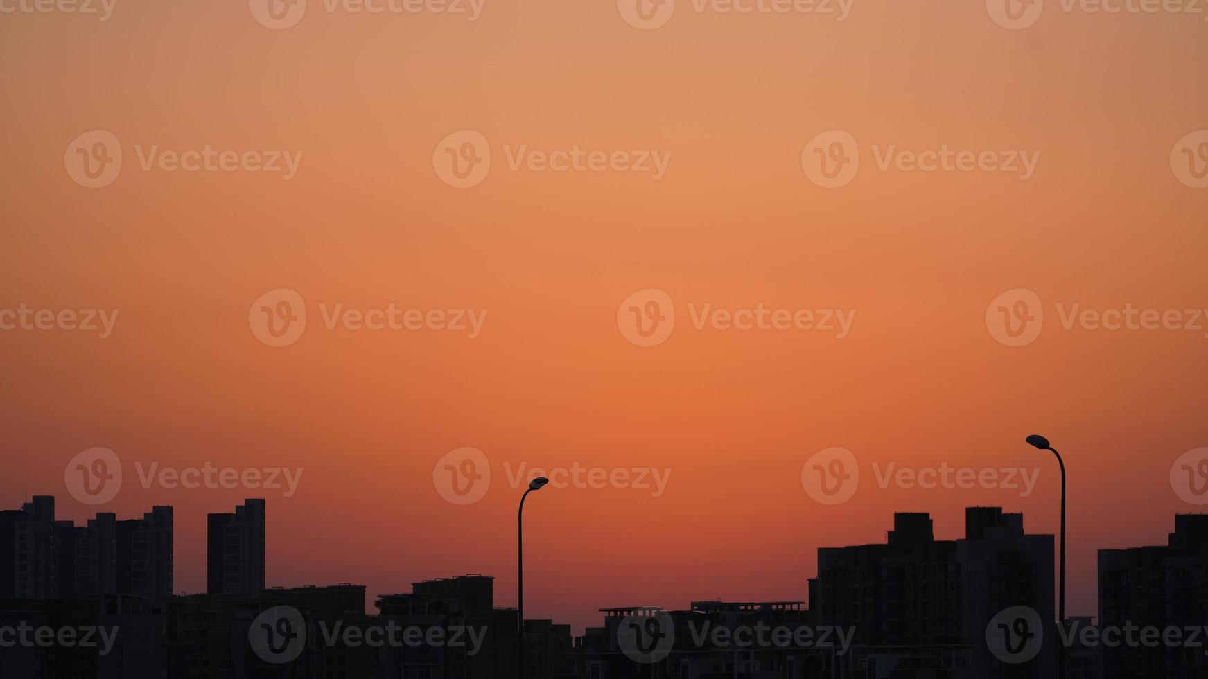 la hermosa vista de la puesta de sol con la silueta y el cielo de nubes coloridas en la ciudad foto