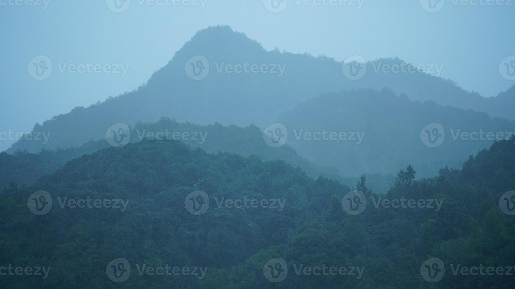 los hermosos paisajes de las montañas con el bosque verde y el pequeño pueblo como fondo en el campo de China foto