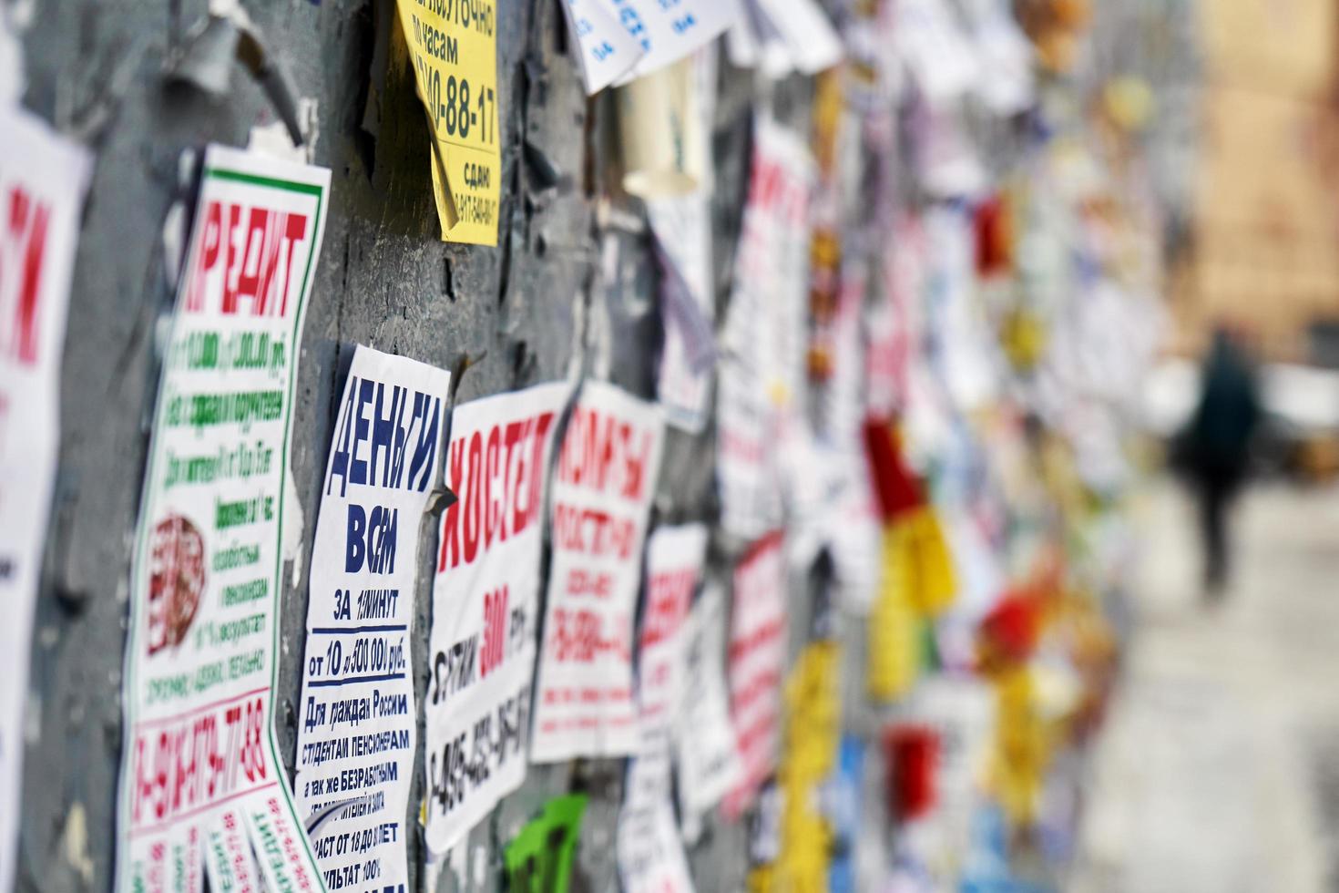 Moscow, Russia - December 08, 2018. Paper advertisements on the shabby wall in Moscow photo
