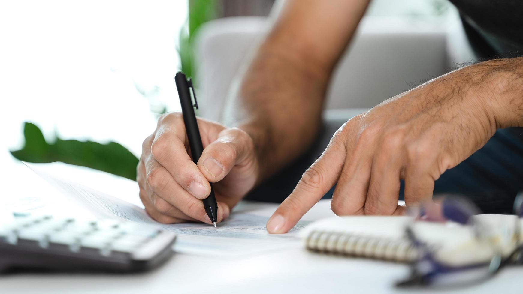 Man is calculating annual tax with calculator and filling form of Individual Income Tax Return. Season to pay Tax and Budget planning concept. photo