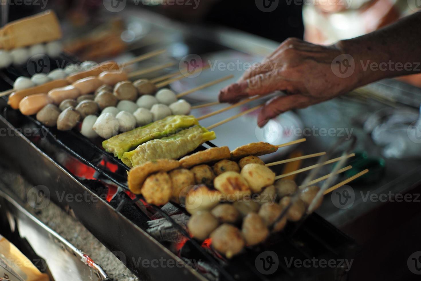 primer plano varios tipos de bolas y salchichas a la parrilla por el carbón. comida de la calle foto