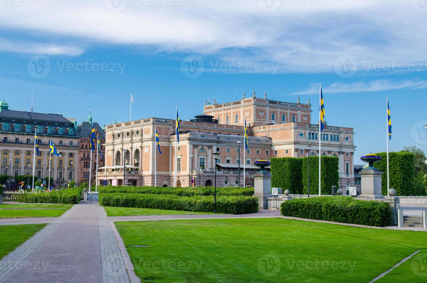 The Royal Swedish Opera house Kungliga Operan building with green bushes and grass lawn foreground photo