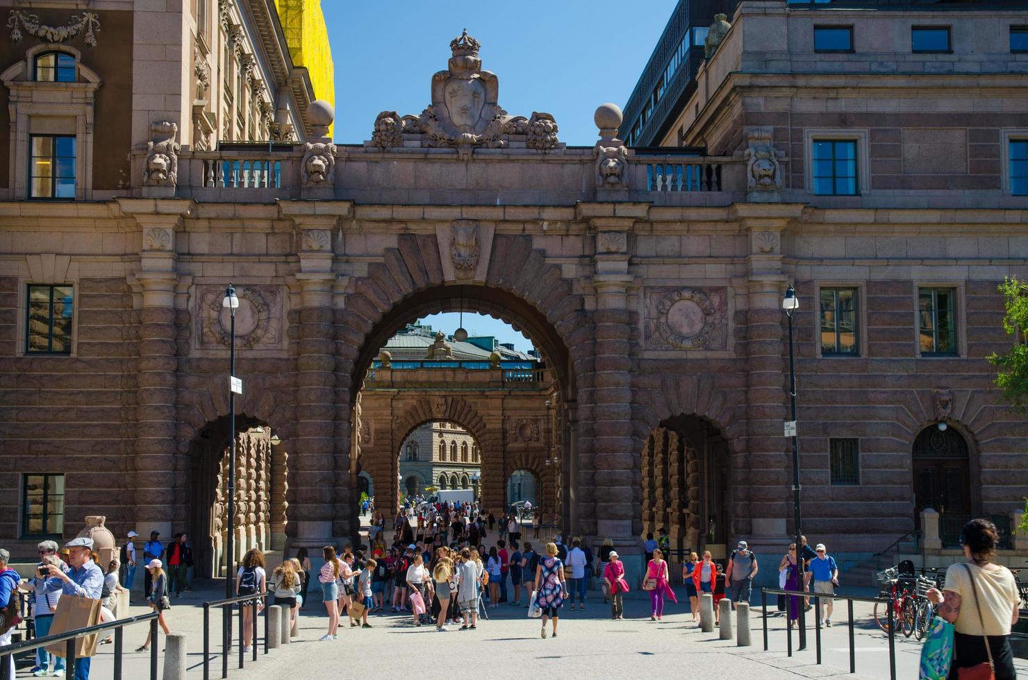 Sweden, Stockholm, May 30, 2018 People walk through Courtyard between arches of Parliament House Riksdag photo