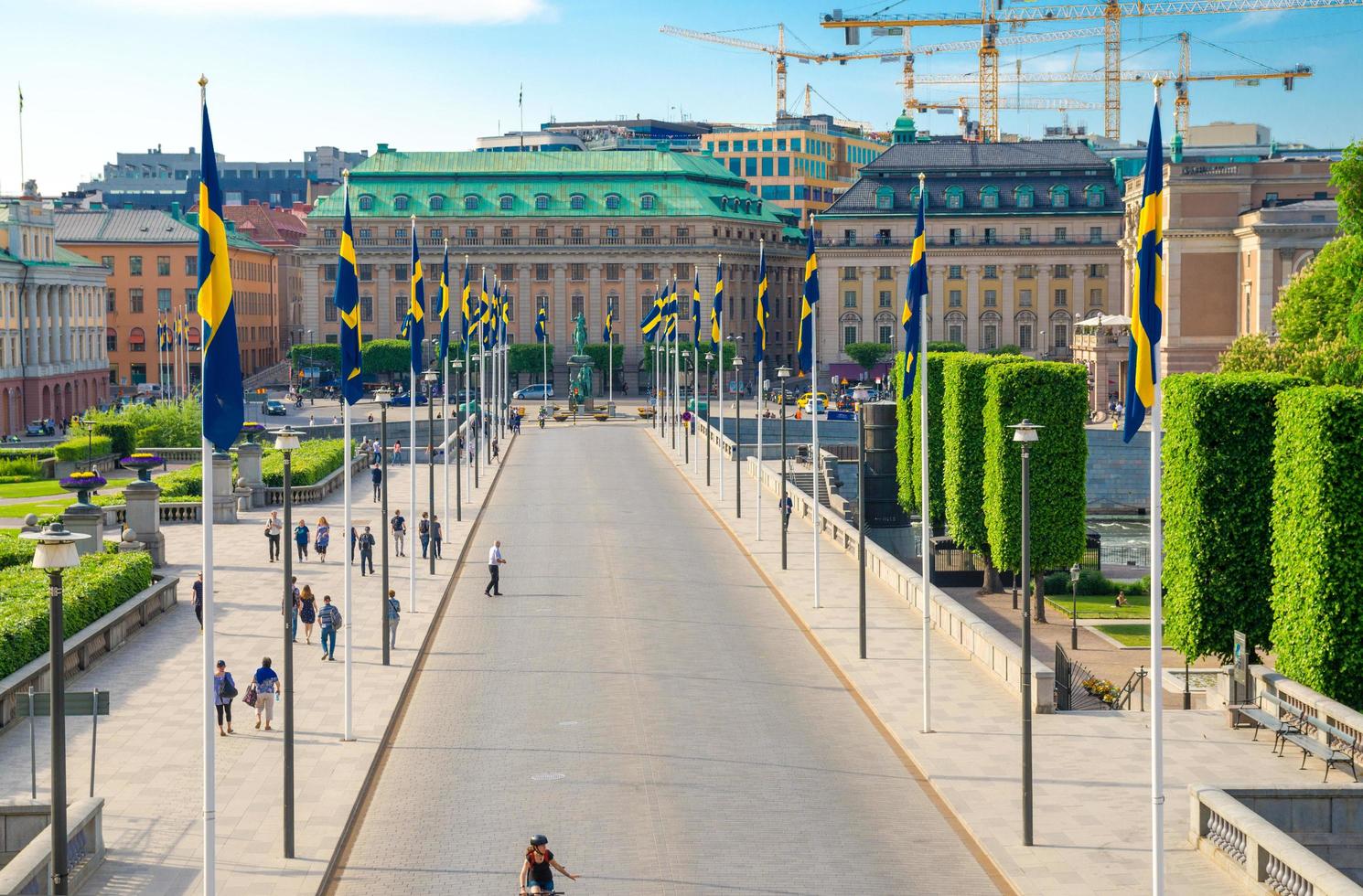 Sweden, Stockholm, May 30, 2018 Riksplan green grass lawn, bushes and street with national flags on Sodermalm island photo