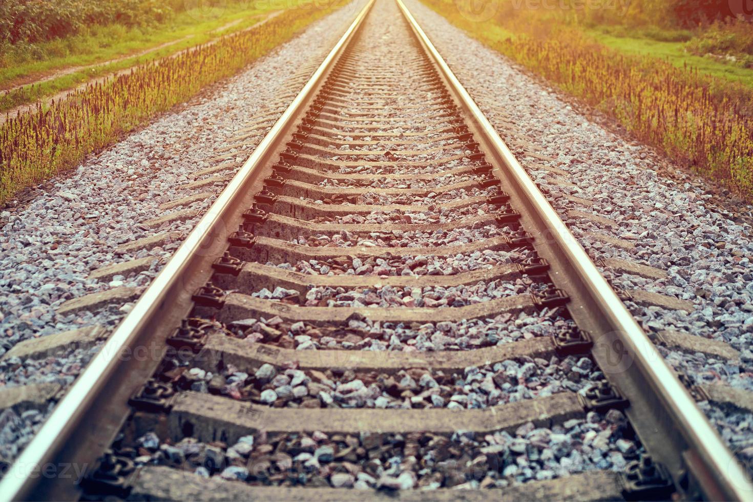 Railway track line in sunlight, railroad train track landscape with ballast gravel and crushed stone photo
