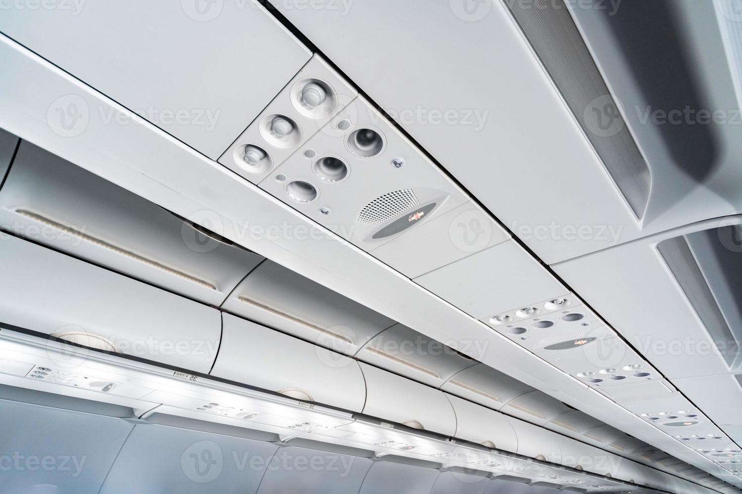 Airplane air conditioning control panel over seats, Stuffy air in aircraft cabin with people, New low-cost airline photo