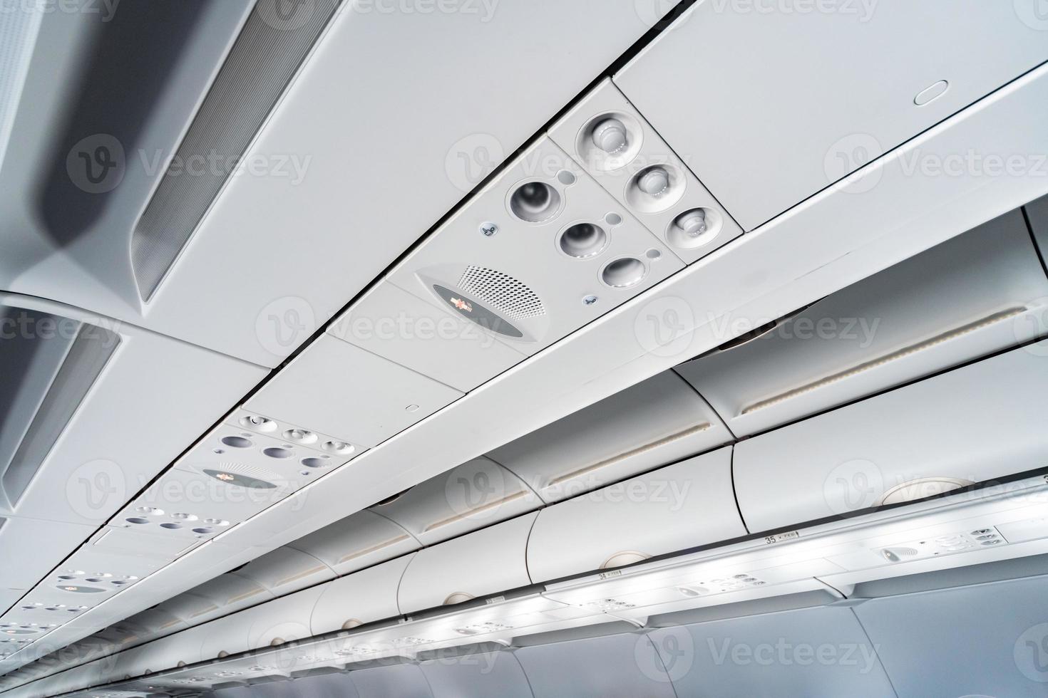 Airplane air conditioning control panel over seats, Stuffy air in aircraft cabin with people, New low-cost airline. photo