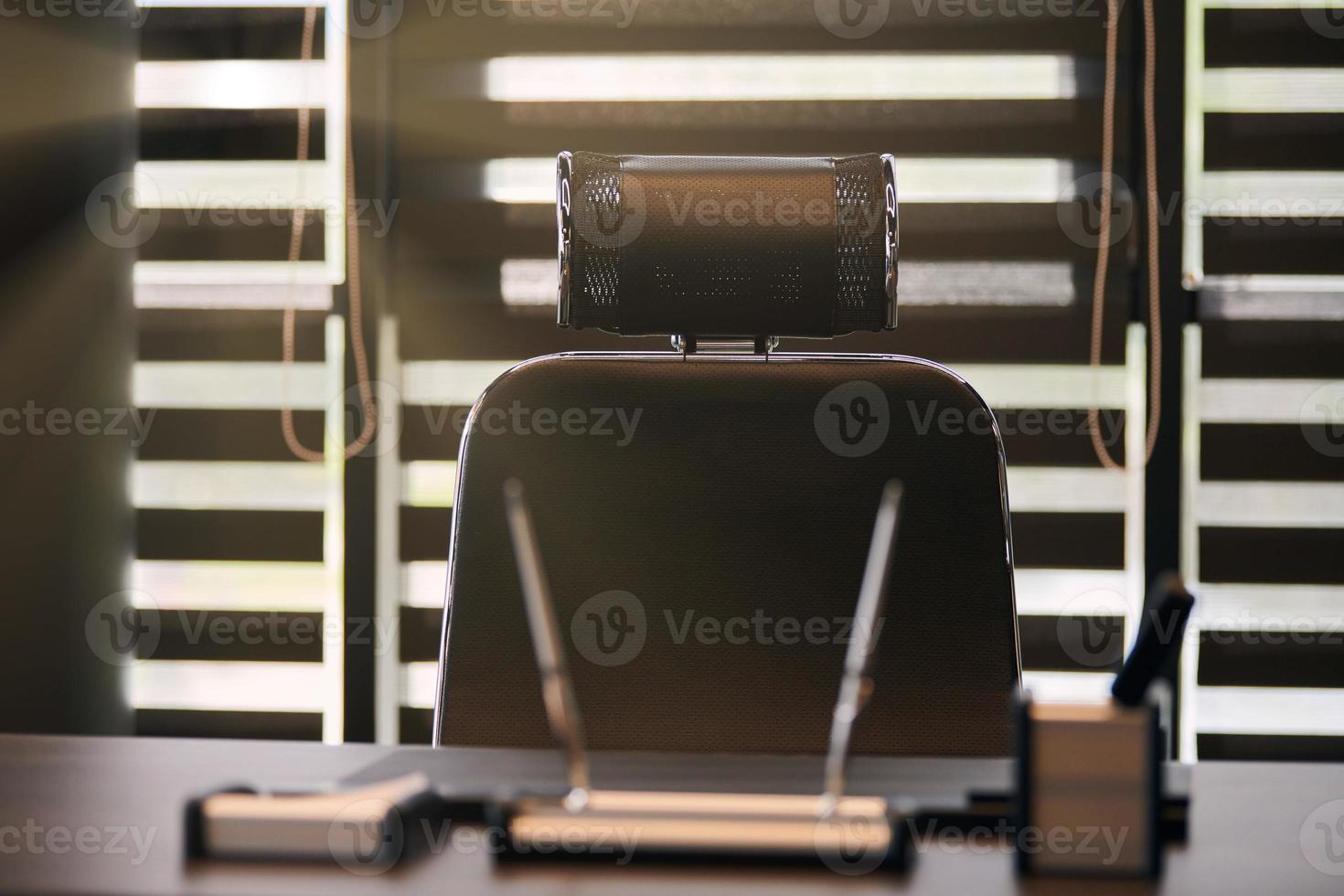 lugar de trabajo de la oficina de negocios. luz solar en el lugar de trabajo para jefe, jefe u otros empleados. mesa y silla cómoda. luz a través de las persianas entreabiertas foto