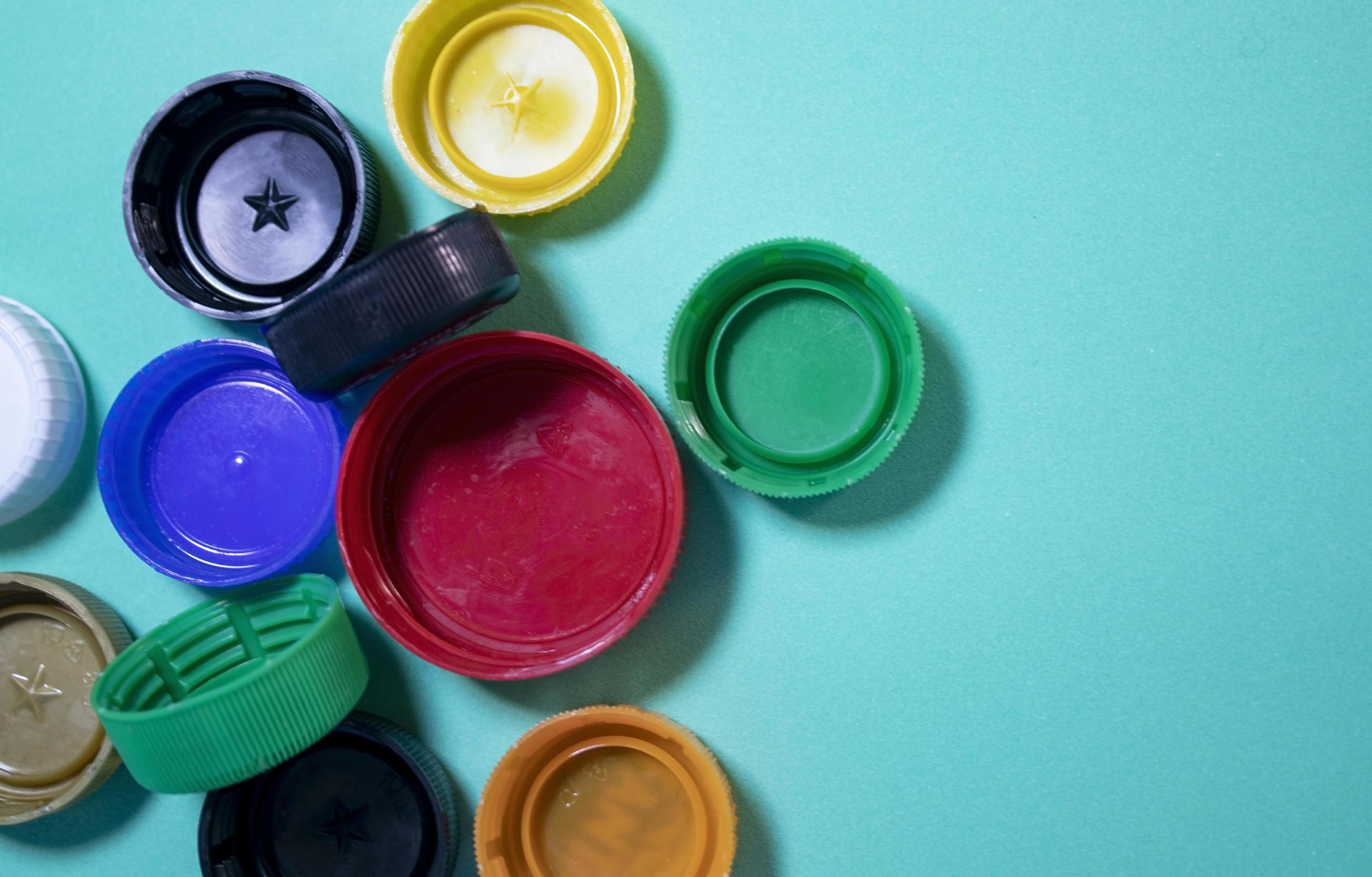 Closeup of multicolored plastic lids. Plastic Lids on a Blue