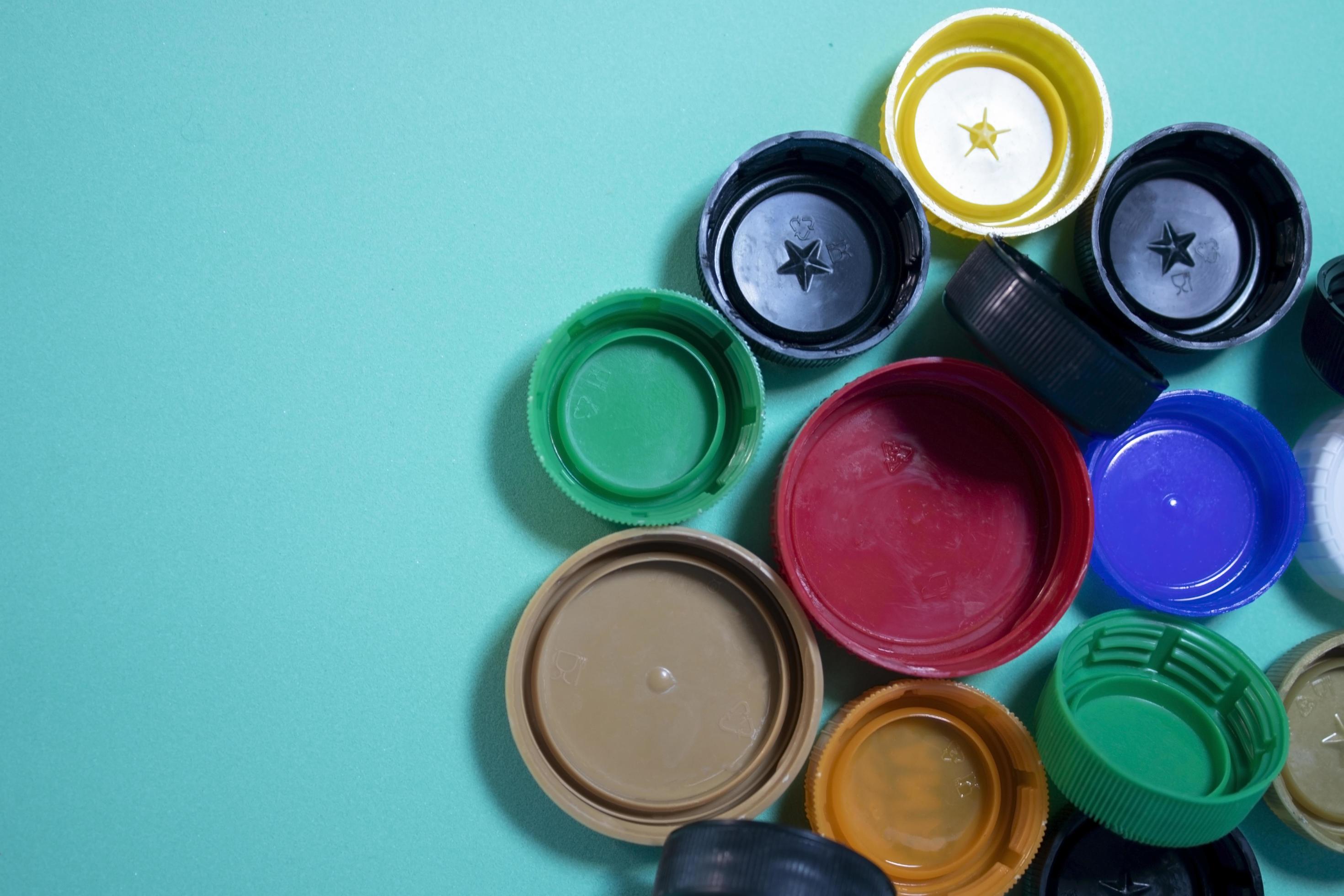 Closeup of multicolored plastic lids. Plastic Lids on a Blue