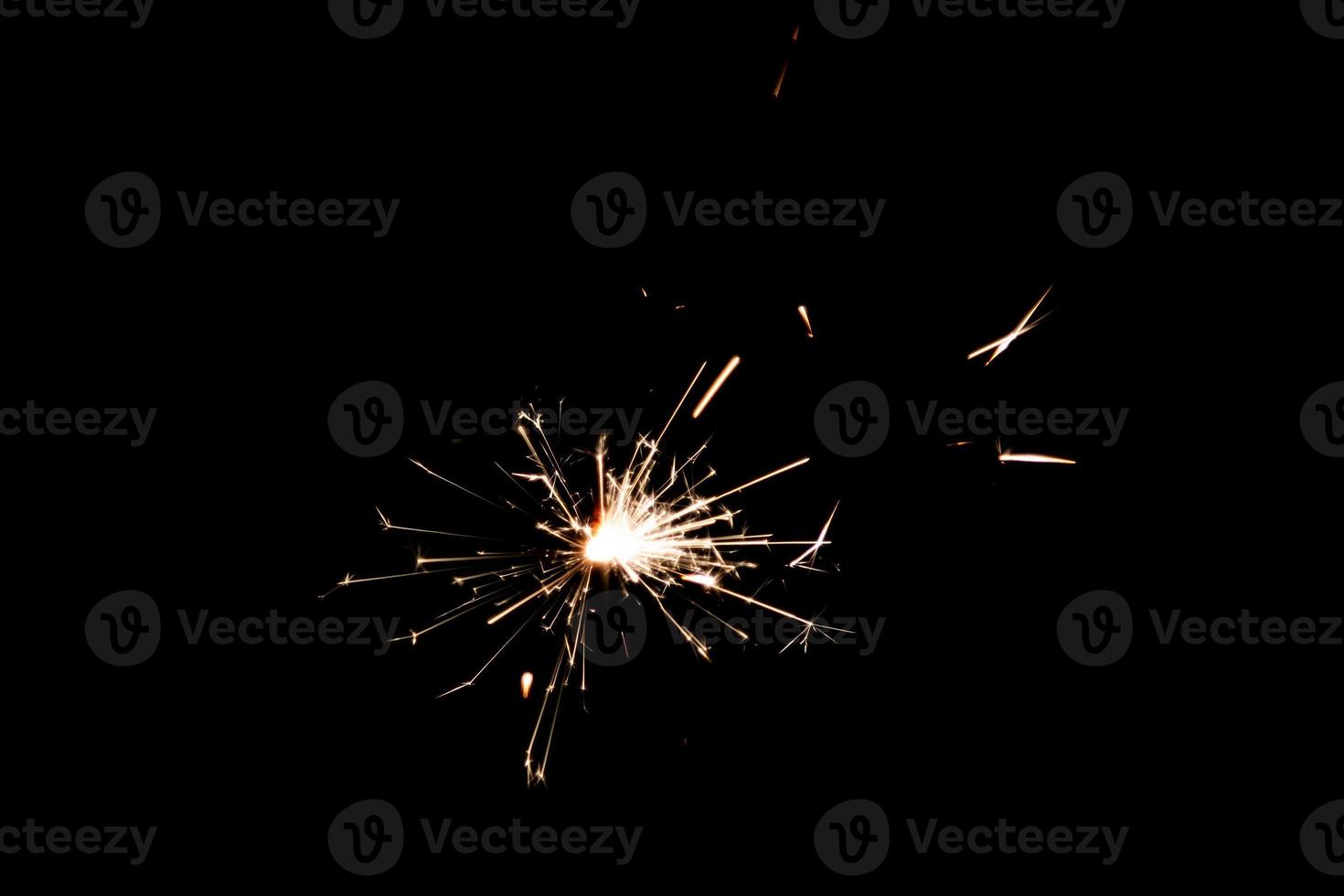 Burning sparkler isolated on black background. Fireworks theme. Light effect and texture. photo