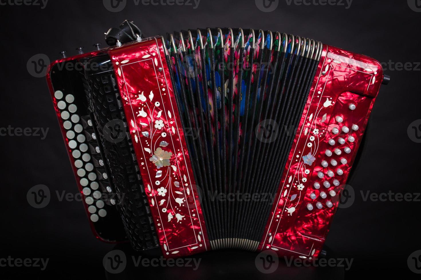 Instrumentos folclóricos rusos bayan rojo sobre un fondo negro acordeón ruso. foto