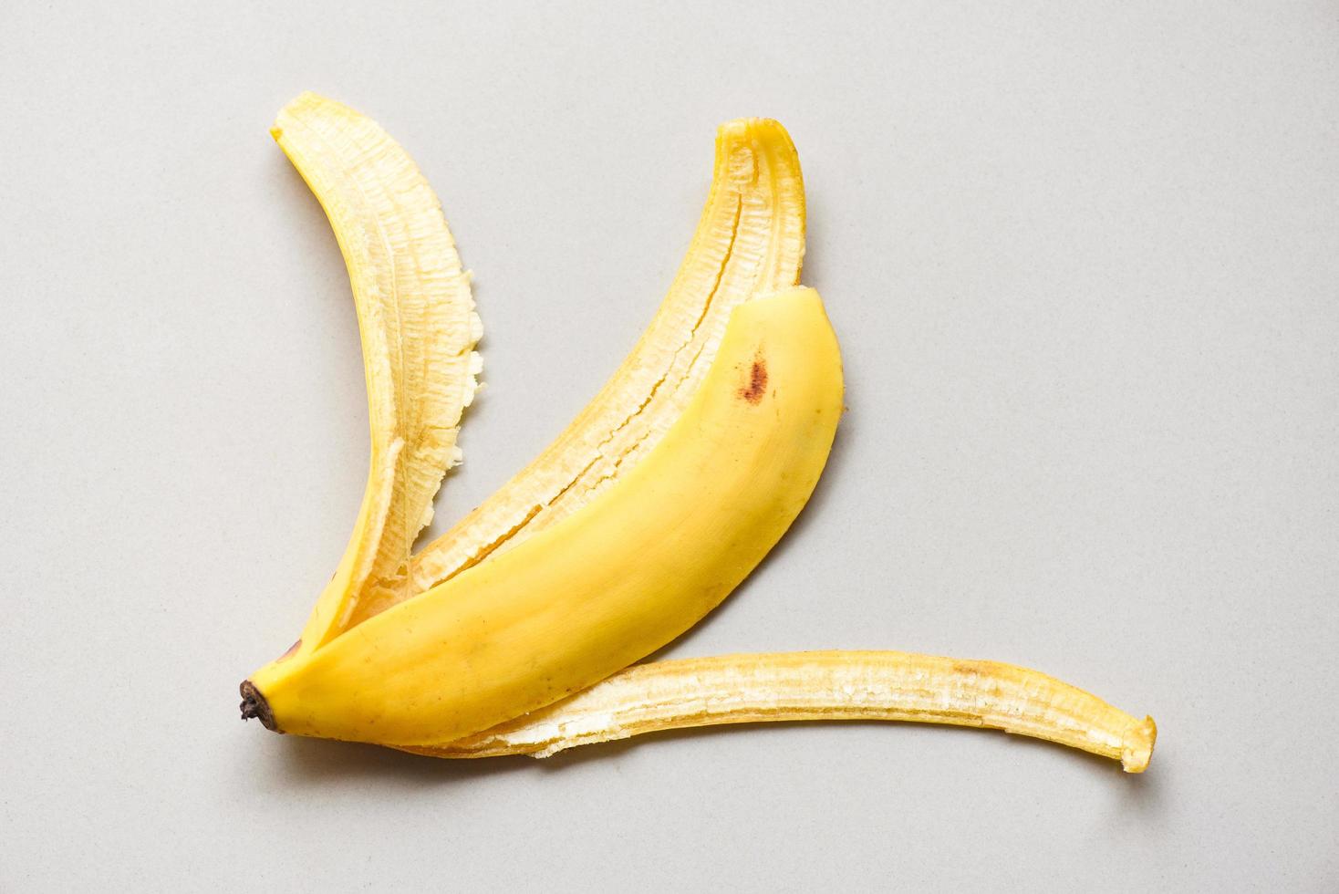 cáscara de plátano sobre fondo gris, cáscara de plátano madura en el suelo - vista superior foto