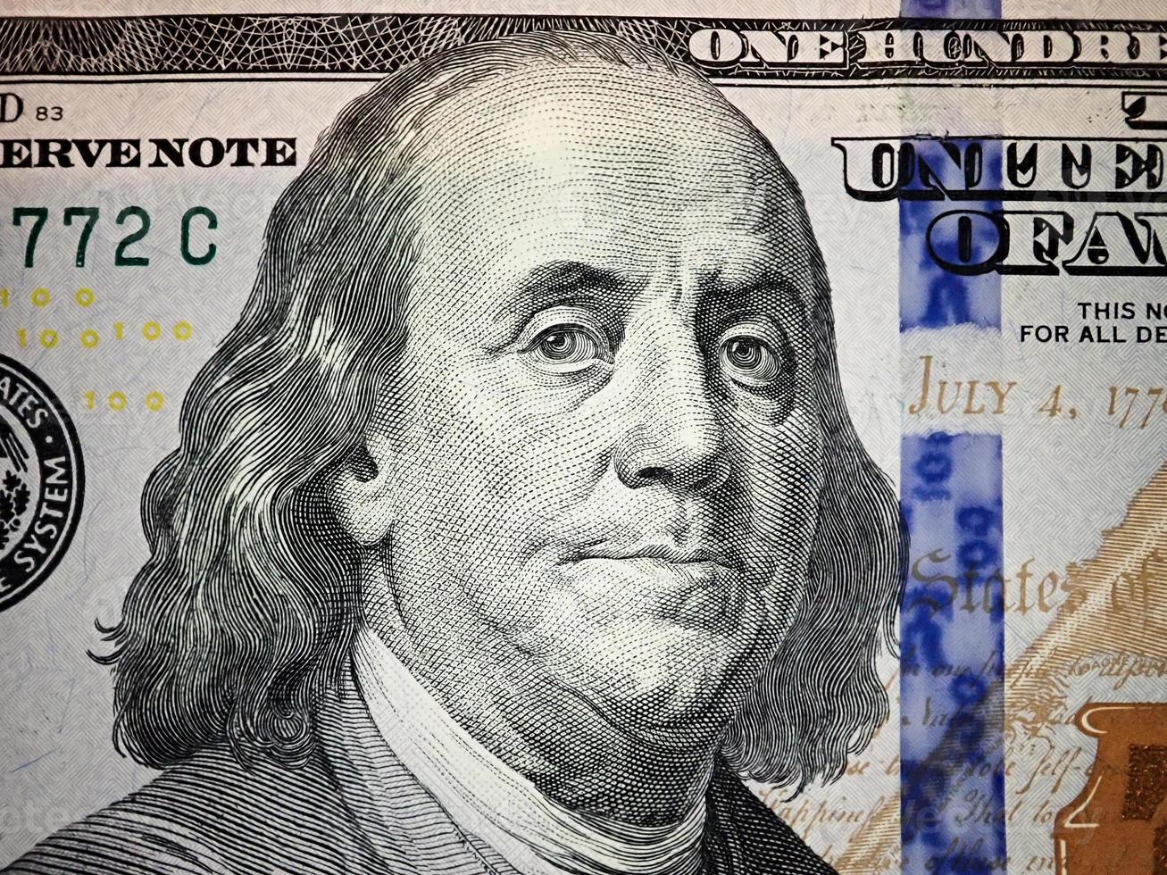 benjamin franklin se enfrenta a nosotros macro de billete de cien dólares. dinero de estados unidos. foto