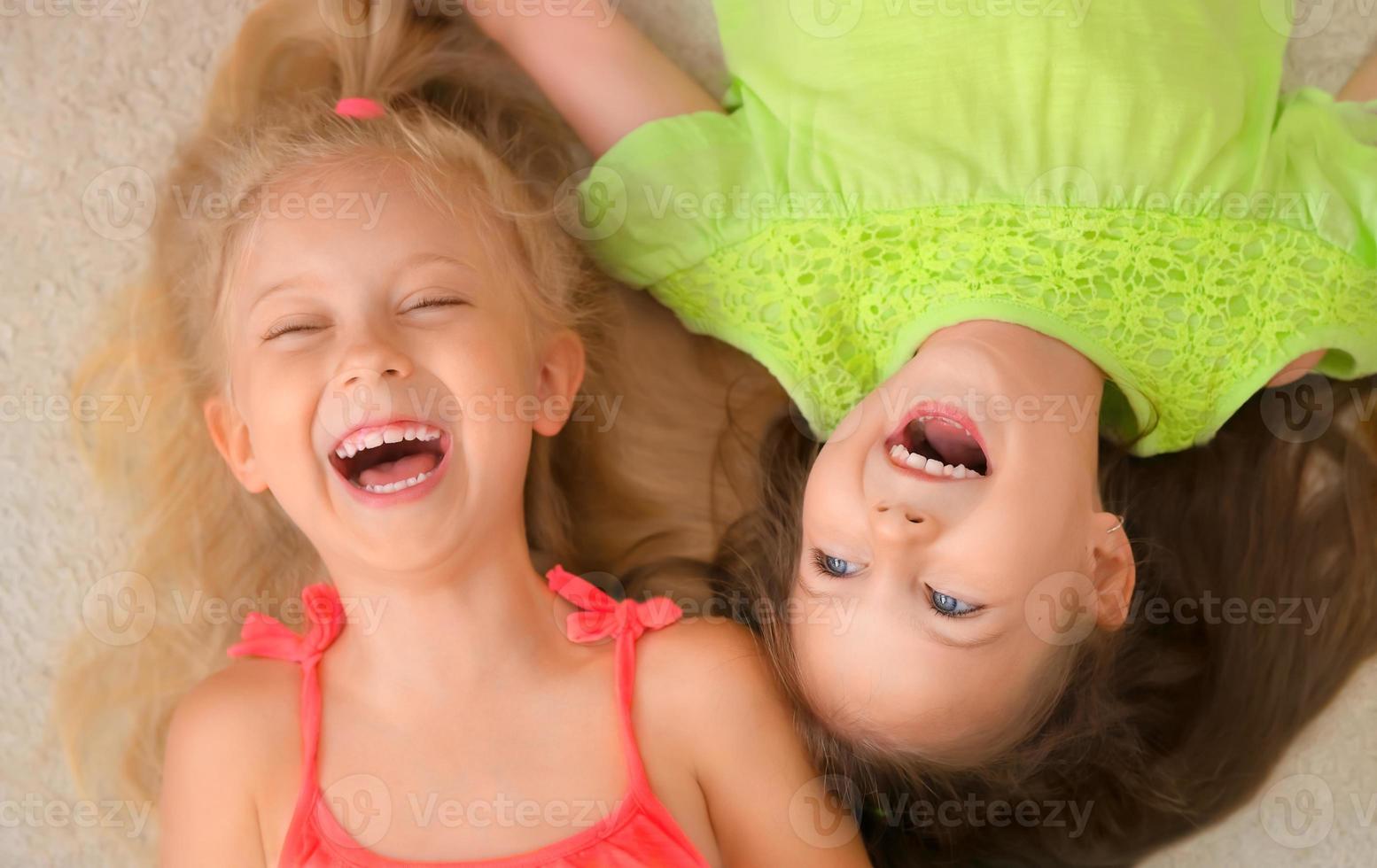 Happy little girls lying on their back. Top view. photo