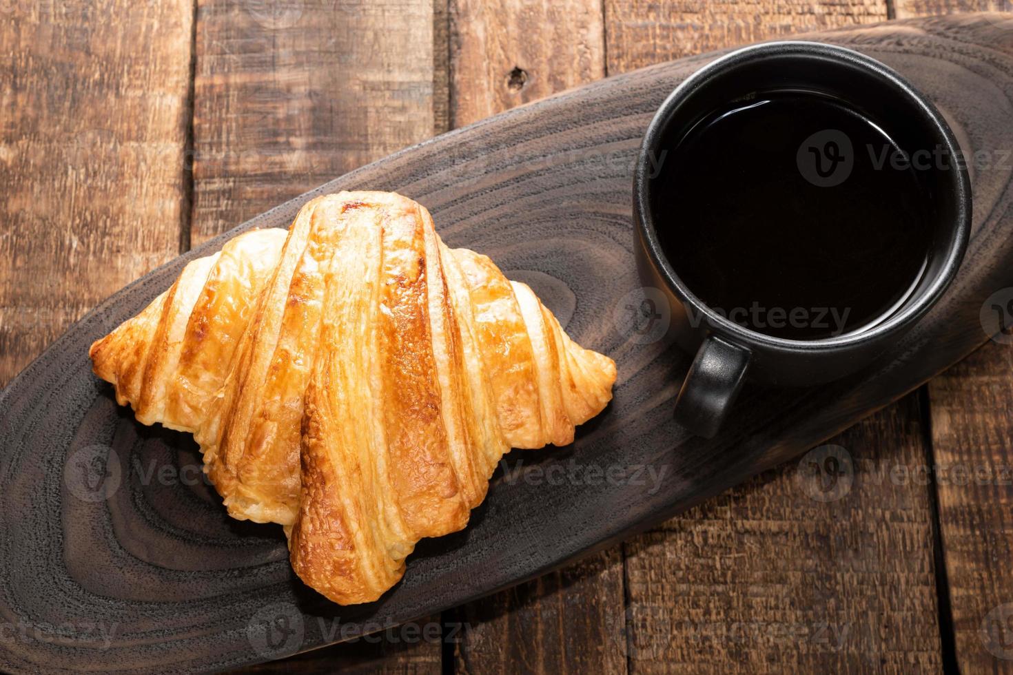 breakfast food coffee and croissant on isolated wood table. photo