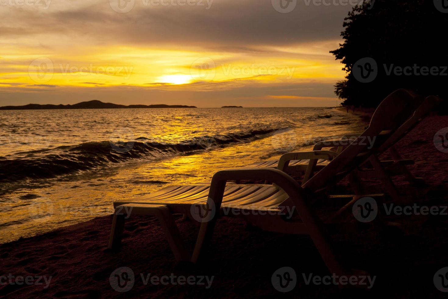 Colorful sunset over sea Pataya beach Thailand with beach chair photo