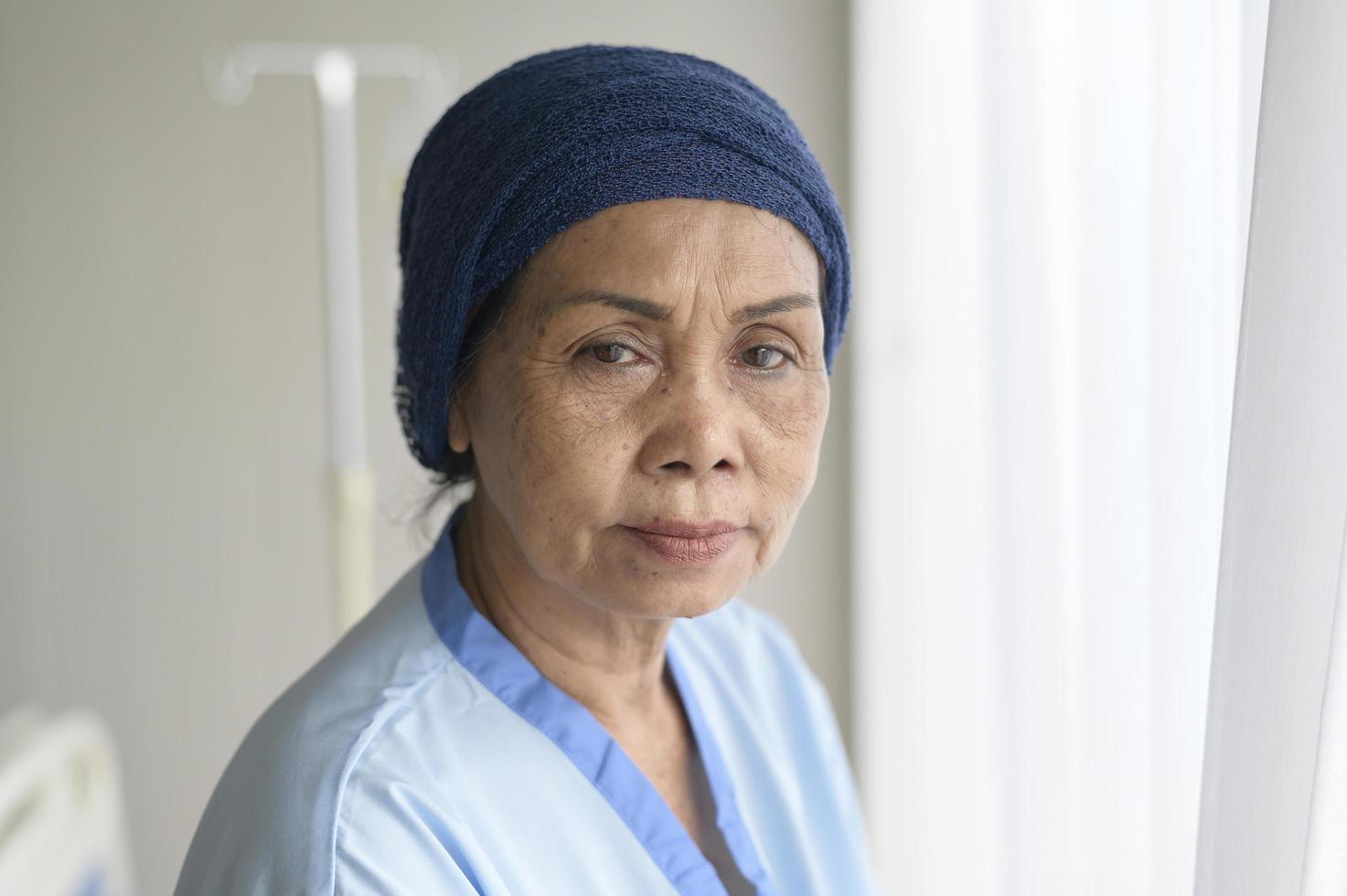 Portrait of senior cancer patient woman wearing head scarf in hospital, healthcare and medical concept photo