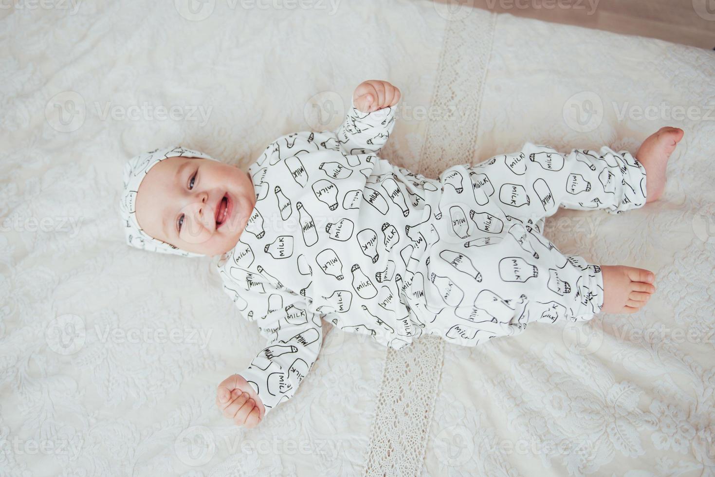 bebé recién nacido vestido con traje en una cama blanda en el estudio. foto