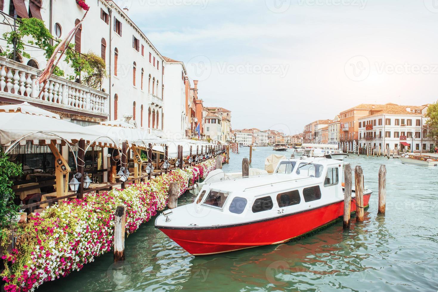 canal de agua verde con góndolas y coloridas fachadas de antiguos edificios medievales al sol en venecia, italia. foto