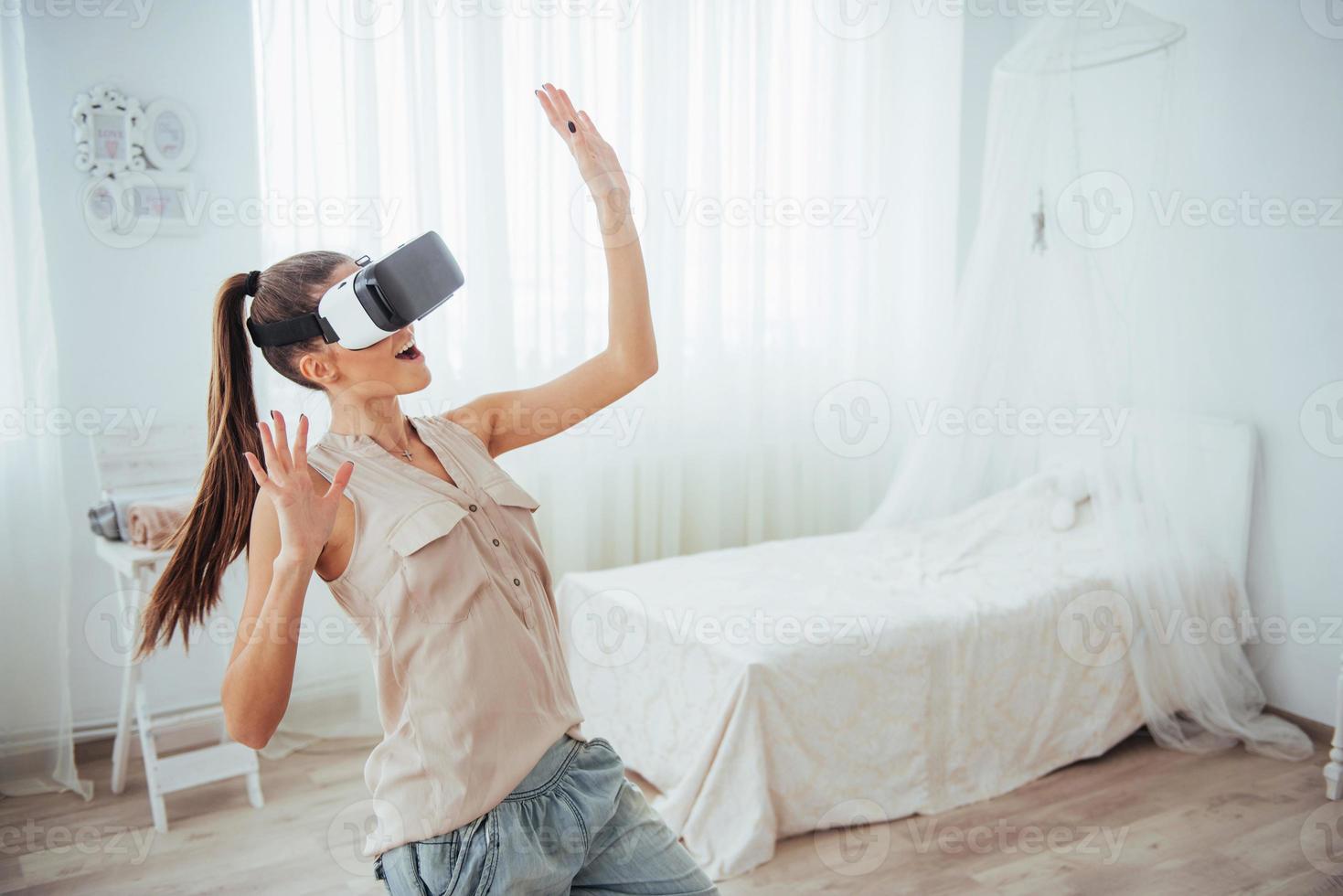 woman gets experience of using VR-glasses virtual reality headset in a bright studio photo