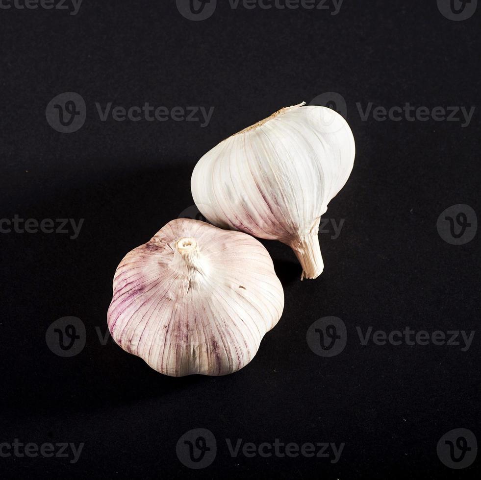 2 fresh garlic bulbs on a black background. photo