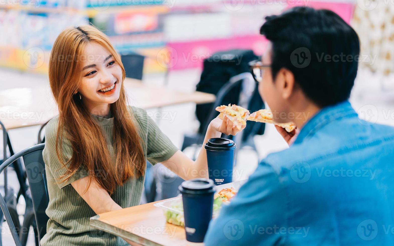 Young Asian couple having lunch together in cafe photo