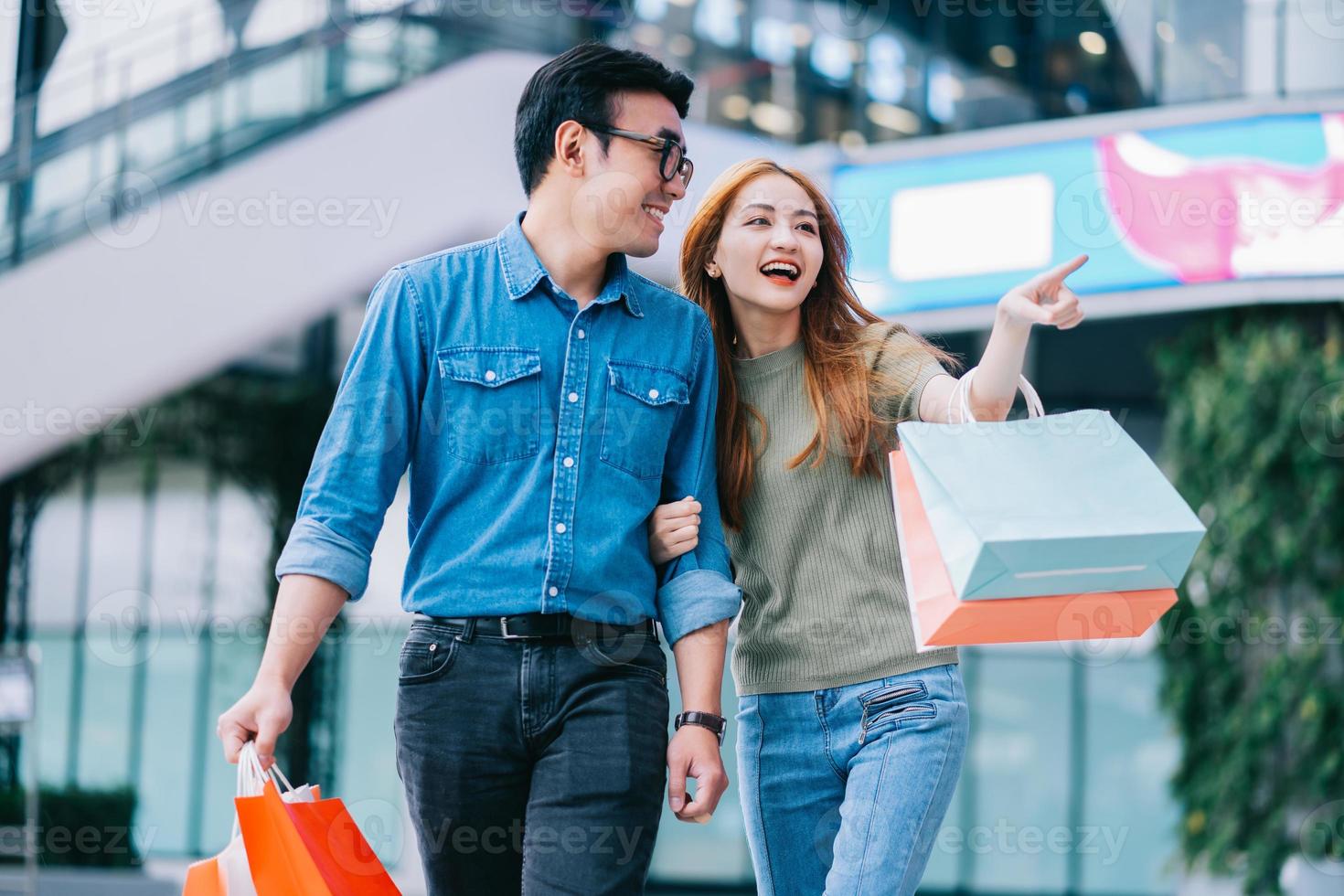 pareja asiática de compras en el centro comercial foto