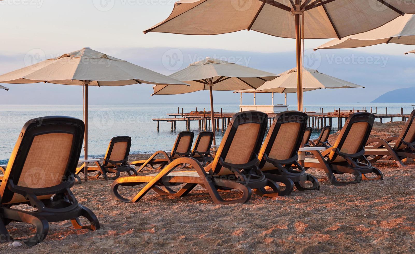 Scenic view of private sandy beach on the beach with sun beds against the sea and mountains. Amara Dolce Vita Luxury Hotel. Resort. Tekirova-Kemer photo