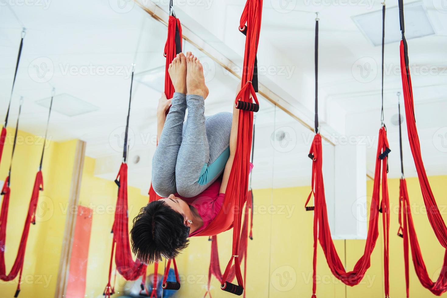 Young women doing yoga exercise or aerial yoga antigravity in the studio. photo