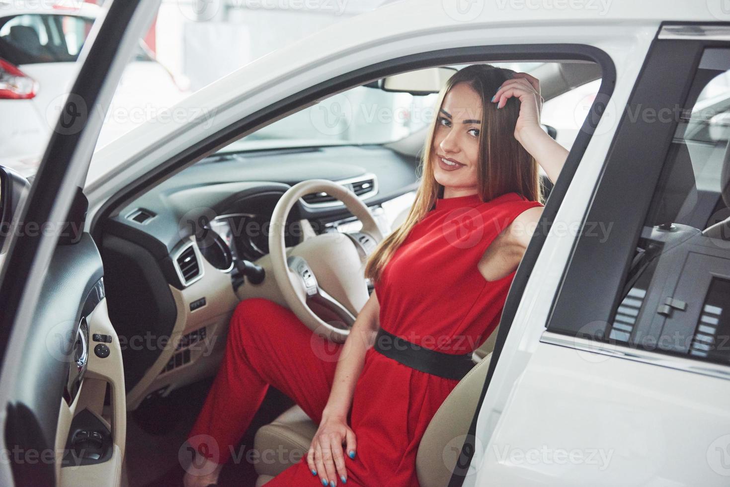 woman in car indoor keeps wheel turning around smiling looking at passengers in back seat idea taxi driver against sunset rays Light shine sky Concept of exam Vehicle - second home the girl photo