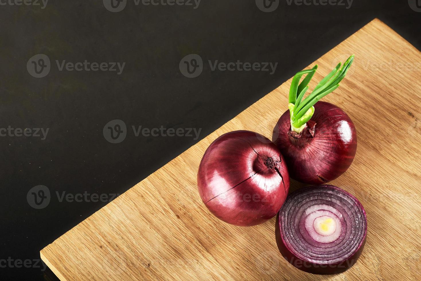 Half red onion on a wooden background photo