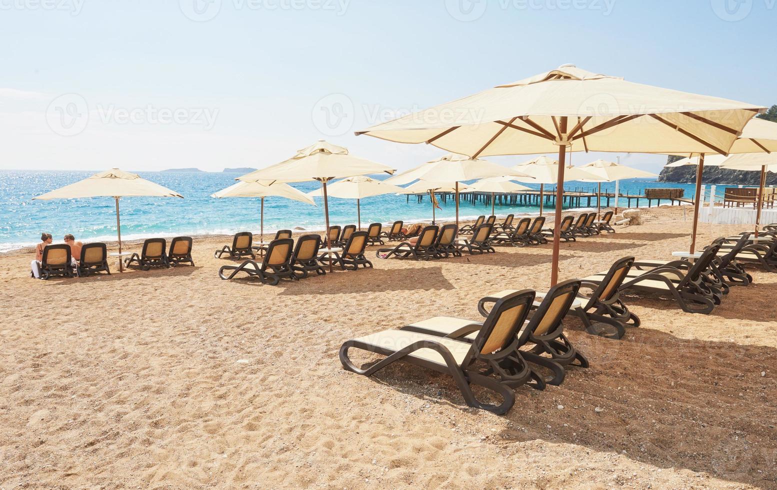 Scenic view of private sandy beach with sun beds from the sea and the mountains. Amara Dols Vita Luxury Hotel. Resort. Tekirova Kemer. Turkey. photo