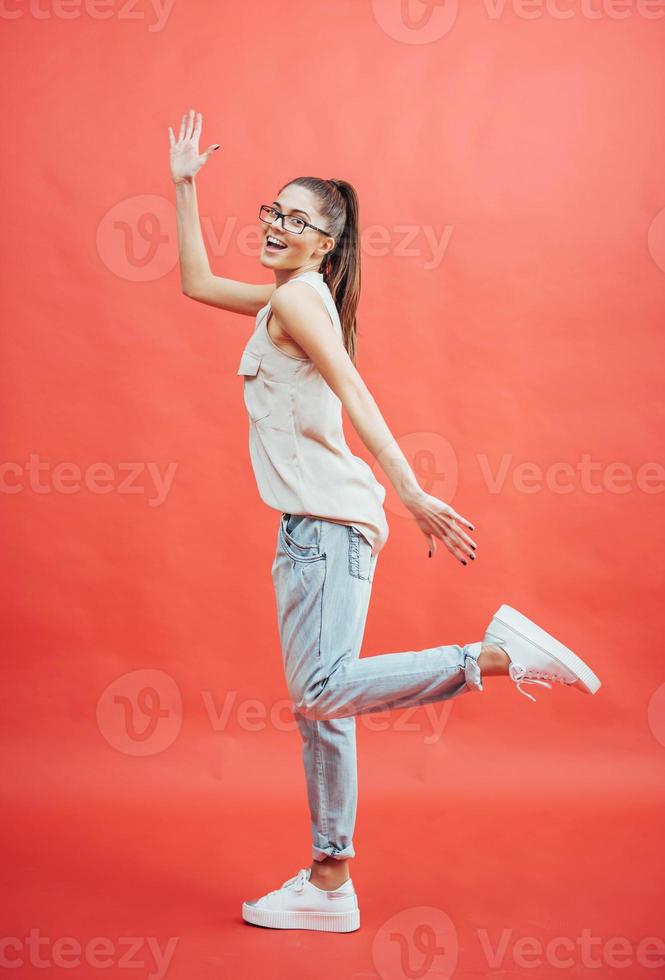 Beautiful young woman in glasses. On a beautiful red background. Beauty, fashion. Makeup. photo