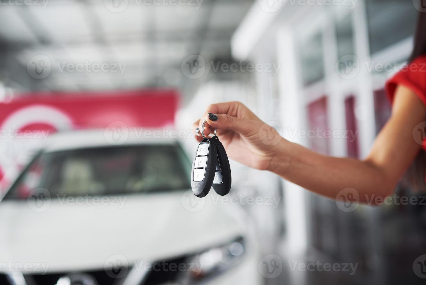 pasando las llaves del coche. Primer plano recortado de un concesionario de automóviles que sostiene las llaves del automóvil a la cámara. foto