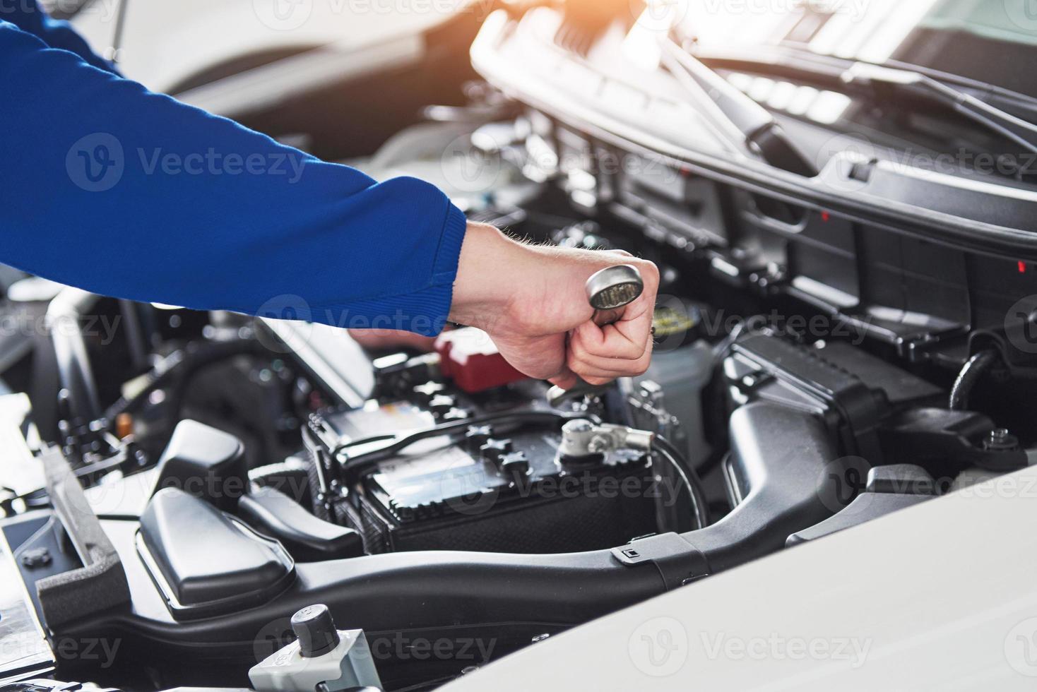 Hands of car mechanic with wrench in garage photo
