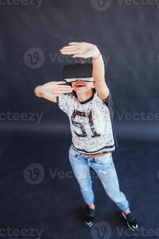 Happy woman gets experience of using VR-glasses virtual reality headset. photo