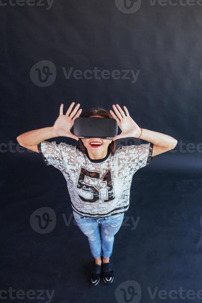 Happy woman gets experience of using VR-glasses virtual reality headset. photo