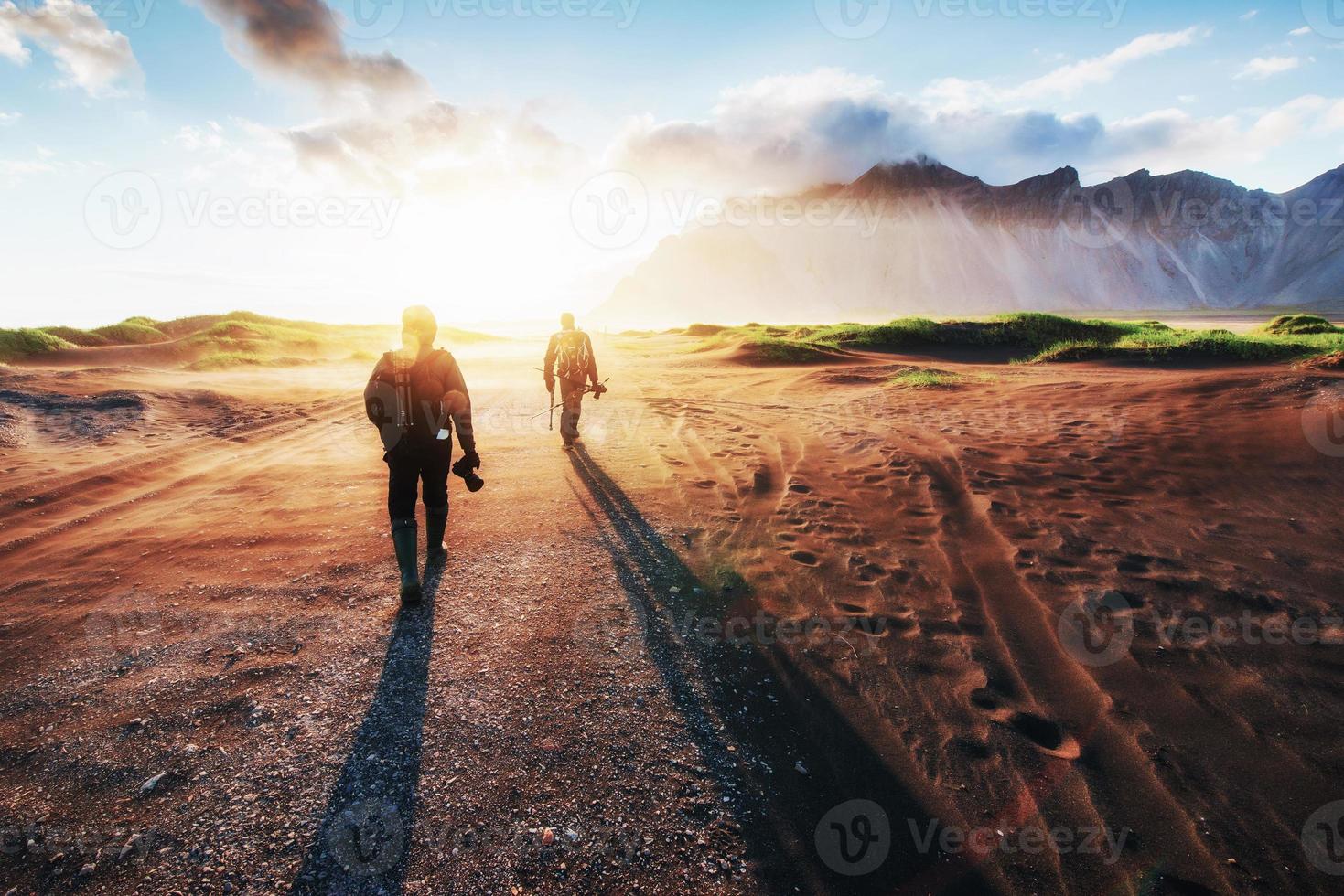 Fantastic west of the mountains and volcanic lava sand dunes to the beach Stokksness. Tourists traveling through the wilderness photo