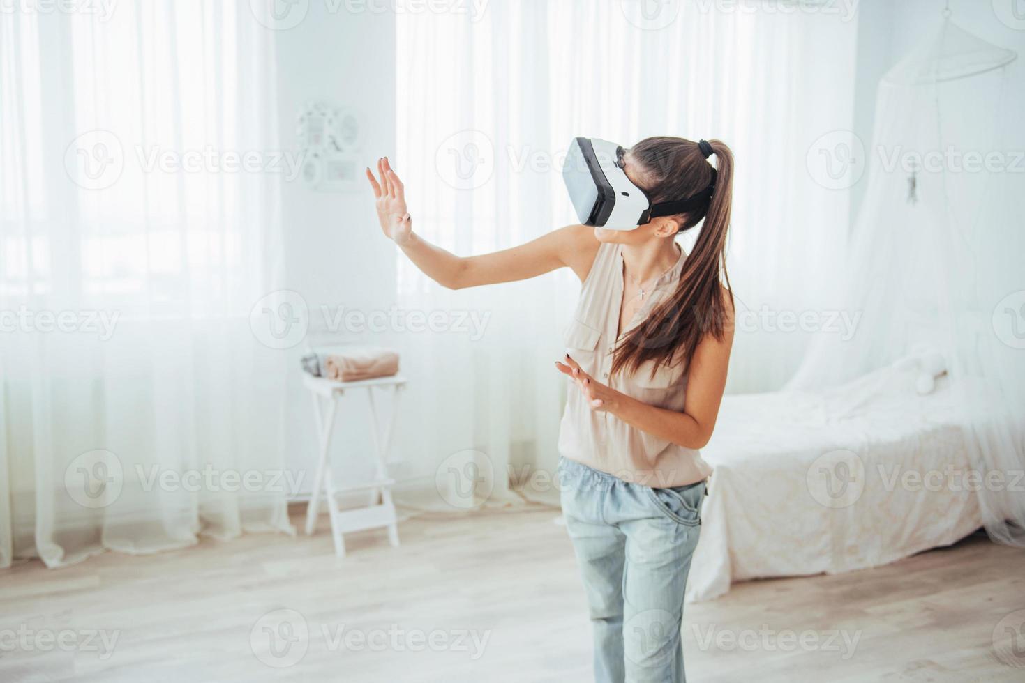 woman gets experience of using VR-glasses virtual reality headset in a bright studio photo